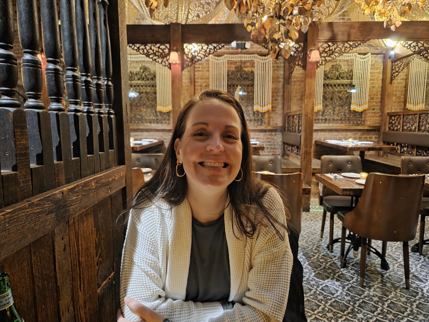Jess smiling warmly at a candlelit restaurant